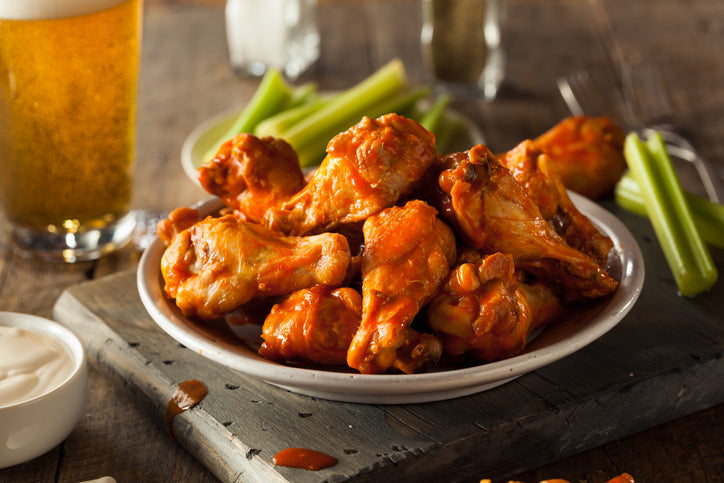 Cooked chicken wings tossed in sauce and served in a bowl