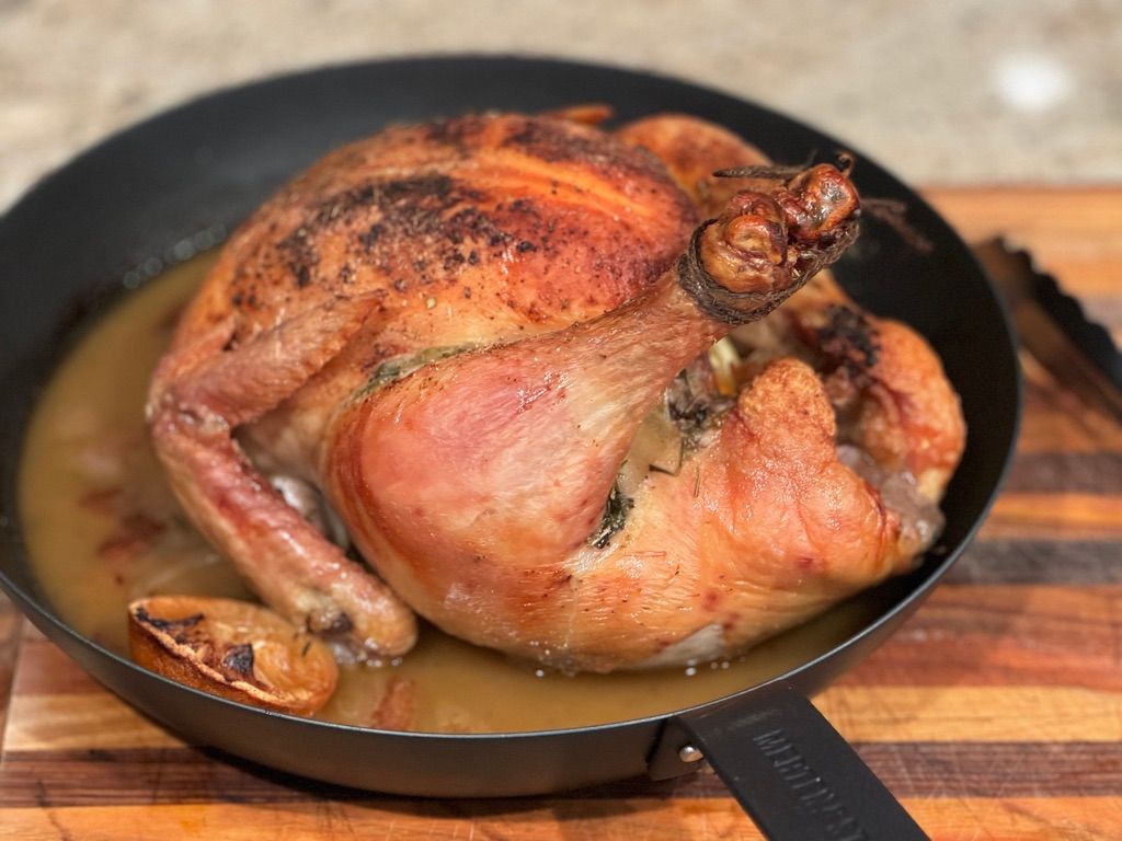 Roasted whole pasture-raised chicken in a cast-iron pan
