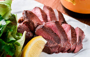 Cooked beef tongue sliced medium rare on plate, from grassfed pasture-raised cattle at Tyner Pond Farm