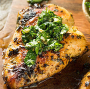 Cooked pasture-raised chicken breast served with green herb sauce