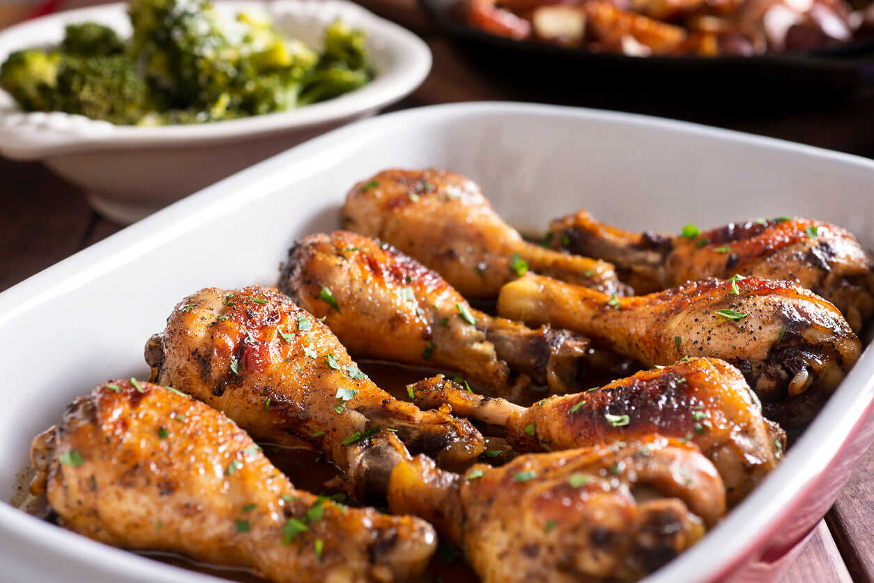 Cooked pasture-raised chicken drumsticks in a baking dish