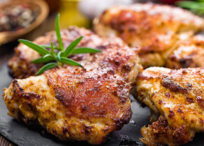 Bone-in pasture-raised chicken thighs with browned skin on a platter