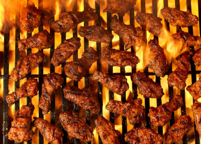 Pasture-raised chicken wings cooking over a grill