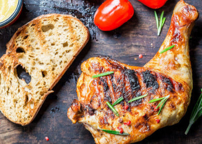 Grilled chicken leg quarter with browned skin and grill marks