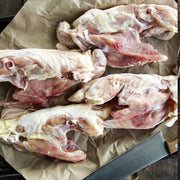 Raw pasture-raised chicken frames arranged on butcher paper