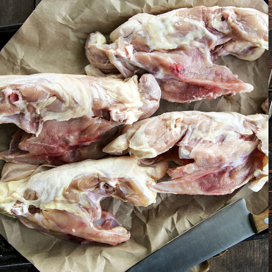Raw pasture-raised chicken frames arranged on butcher paper