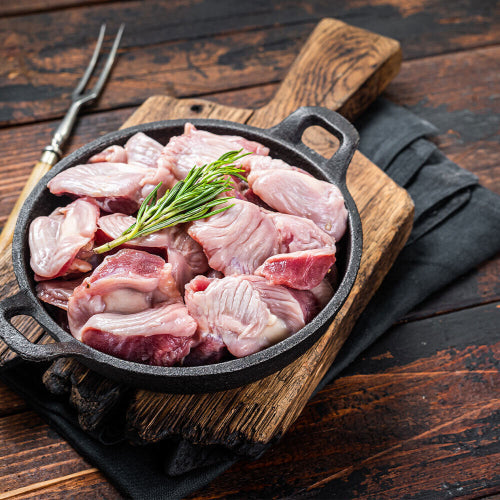 Raw pasture-raised chicken gizzards on a cutting board