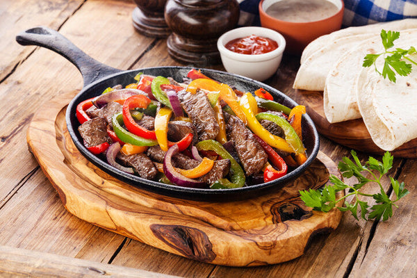 Grilled grassfed skirt steak sliced for fajitas with peppers and onions, pasture-raised at Tyner Pond Farm