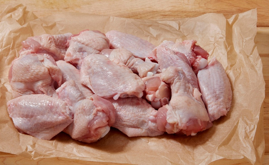 Raw pasture-raised chicken wings arranged on butcher paper